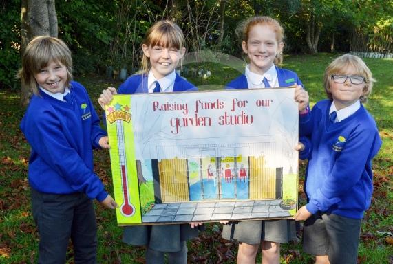 Eddie Dixon-Ainscough (9), Bryony Stewart (11), Jessica Lord (10) and Ryan Milnes (9) with the Progress Board showing fundraising totals for the Garden Studio at Crazies Hill Primary School.