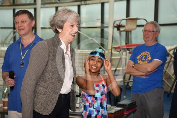 The Prime Minister Theresa May talks to swimmer Divya Thirakaluthy, nine, at the 34th Maidenhead Swimarathon.The Prime Minister Theresa May and Philip May visit the 34th Maidenhead Swimarathon at the  Magnet Leisure Centre, Holmanleaze, Maidenhead. 