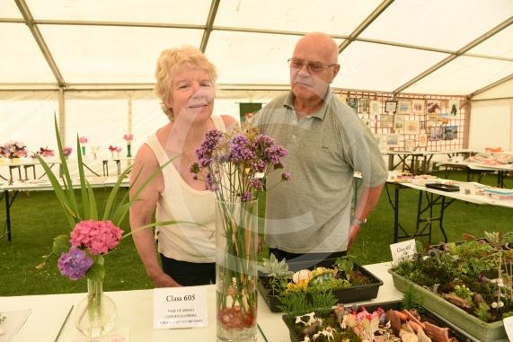 Julia Burrowes and John Burrowes look at the vases of mixed garden flowers.Annual Stoke Poges Horticultural showStoke Poges school, Rogers Lane, Stoke Poges.