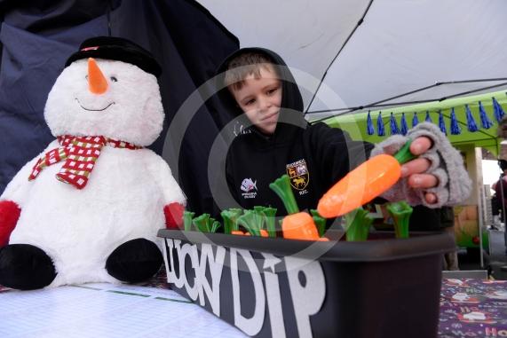 Fred Mellors, six, plays the Holy Trinity C of E School lucky dip game.Cookham Christmas Street Fayre 2019, High Street, Cookham.