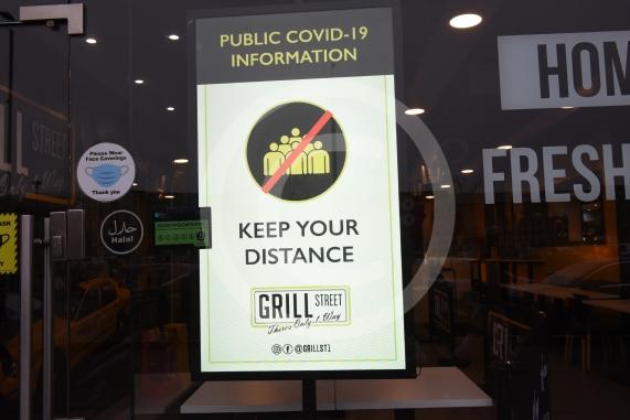 Grill Street owner Bilal Malik , has put up electronic awareness raising signs for COVID-19. Grill Street, 232 Farnham Rd, Slough 