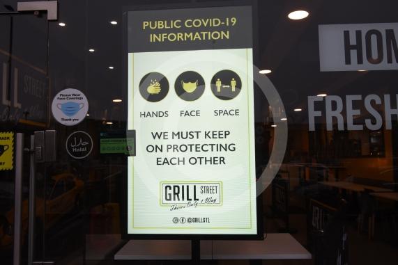 Grill Street owner Bilal Malik , has put up electronic awareness raising signs for COVID-19. Grill Street, 232 Farnham Rd, Slough 