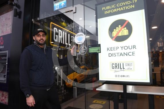 Grill Street owner Bilal Malik , has put up electronic awareness raising signs for COVID-19. Grill Street, 232 Farnham Rd, Slough 