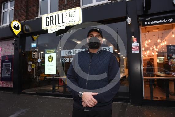 Grill Street owner Bilal Malik , has put up electronic awareness raising signs for COVID-19. Grill Street, 232 Farnham Rd, Slough 