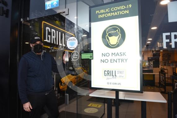 Grill Street owner Bilal Malik , has put up electronic awareness raising signs for COVID-19. Grill Street, 232 Farnham Rd, Slough 